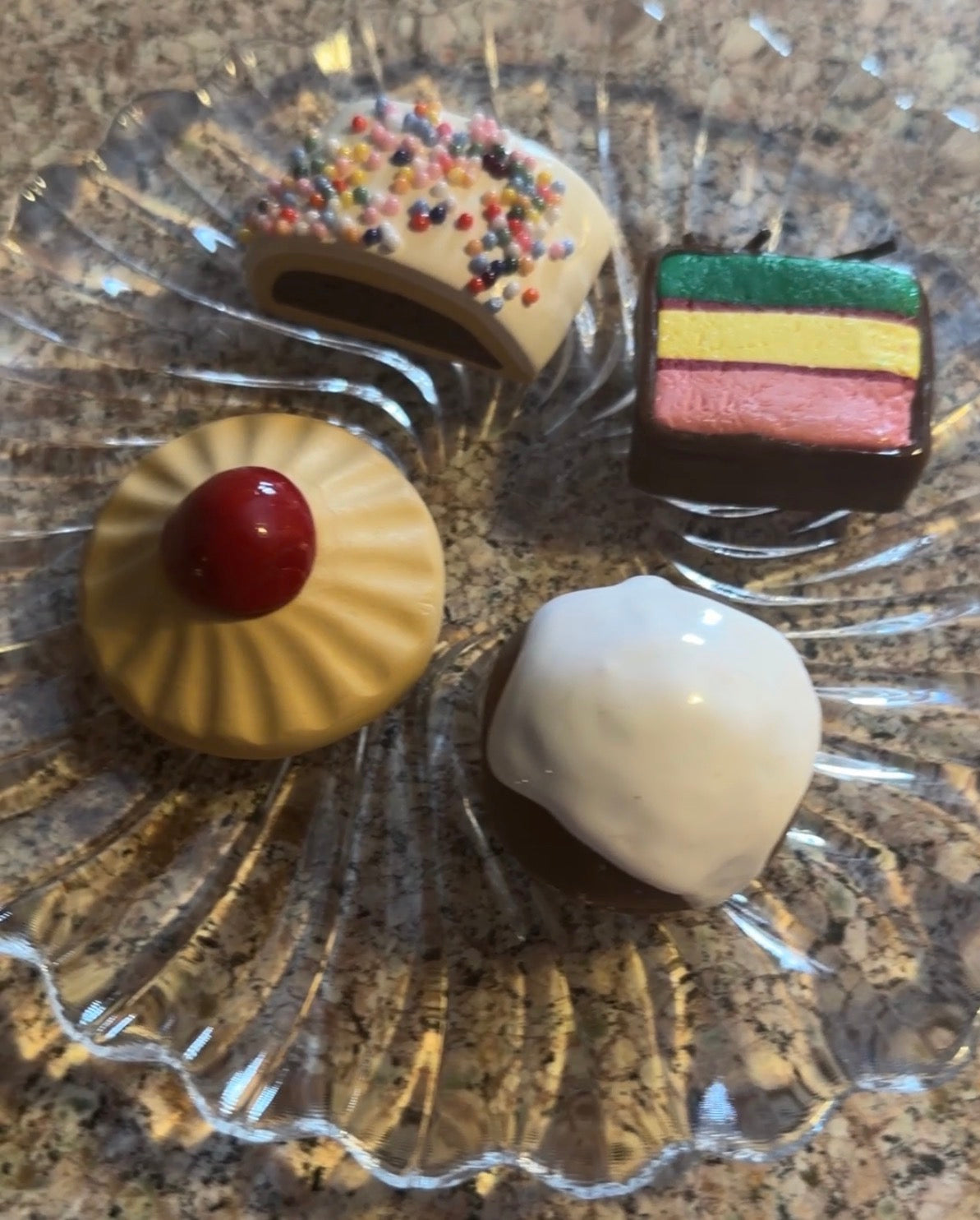 Assorted small desserts on a decorative glass plate